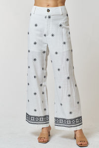 Descubre nuestro pantalón largo y ancho de lino con bordado paisley y cierre de botones